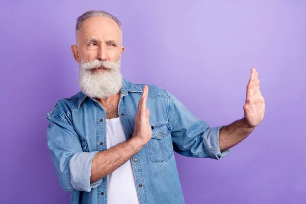 Photo of charming confident mature man dressed denim outfit showing no looking empty space isolated purple color background — Fotografia de Stock