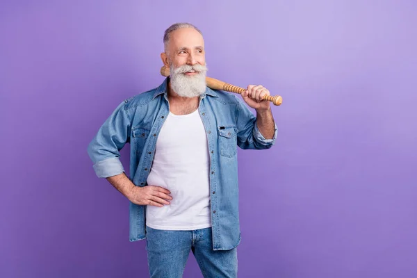 Photo of confident cute age gentleman wear jeans shirt arm waist holding bit looking empty space isolated violet color background — Fotografia de Stock