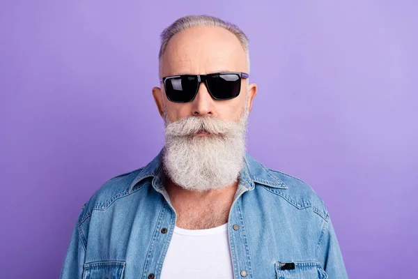 Portrait of serious brutal old man touch his fashionable specs look feel negative  wear red stylish sweater isolated over grey concrete wall color background  Stock Photo