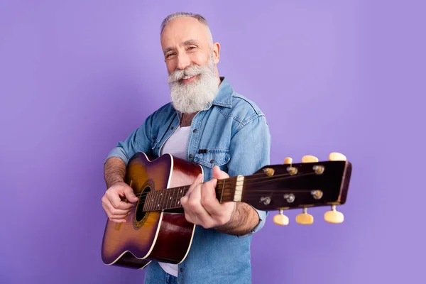 Profiel zijkant foto van de oude man gelukkig positieve glimlach spelen gitaar prestaties geïsoleerd over paarse kleur achtergrond — Stockfoto