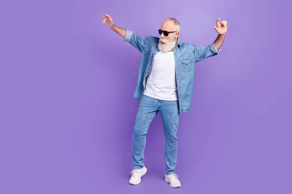 Full size photo of excited senior man dance music clubber look empty space isolated over purple color background — Stok Foto