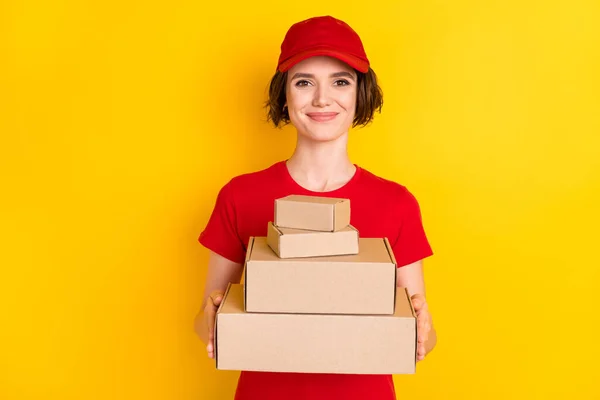 Photo of nice optimistic brown hair lady hold box wear t-shirt cap isolated on yellow background — Stok fotoğraf
