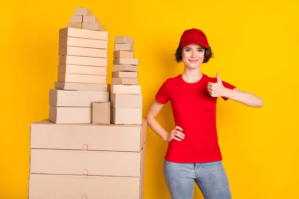 Photo portrait of woman showing thumb-up sign near big pile of boxes shipment service isolated vibrant yellow color background — Stok fotoğraf