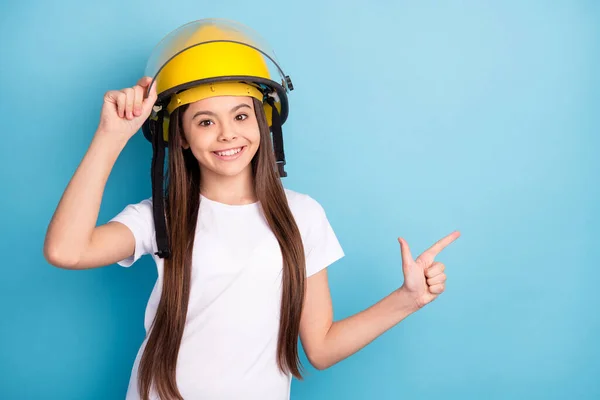 Foto von jungen Mädchen glücklich positives Lächeln tragen Helm Zeigefinger leeren Raum ad promo vorschlagen isoliert über blaue Farbe Hintergrund — Stockfoto