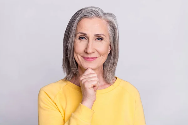 Photo of thoughtful pretty age woman dressed yellow outfit smiling arm chin isolated grey color background — Stockfoto