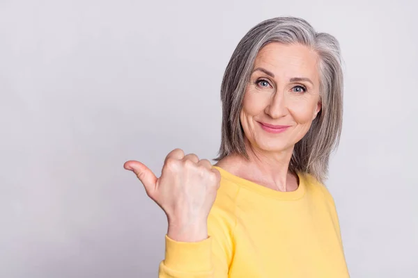 Portret van mooie positieve glimlachende volwassen vrouw aanbevelen product aanbod geïsoleerd op grijze achtergrond — Stockfoto