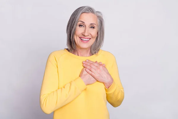 Photo of happy cheerful excited lovely mature woman hold hands chest grateful isolated on grey color background — Fotografia de Stock