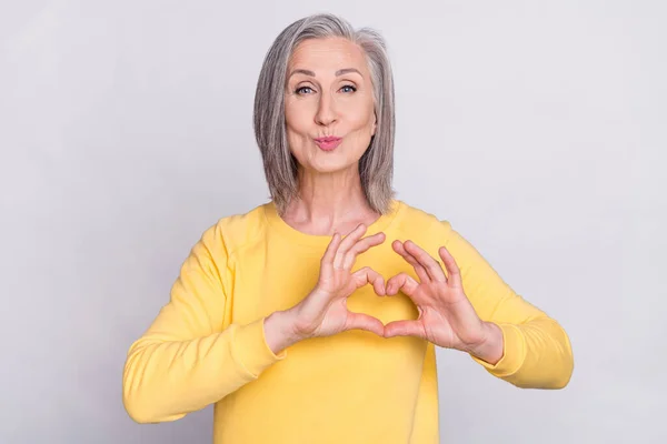 Photo of beautiful charming mature woman pout lips kiss showing heart shape gesture isolated on grey color background — Fotografia de Stock