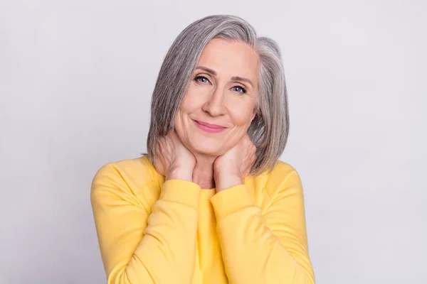 Fotografie šťastné dobré nálady docela okouzlující usměvavá starší žena nosit žlutý svetr izolované na šedém pozadí — Stock fotografie