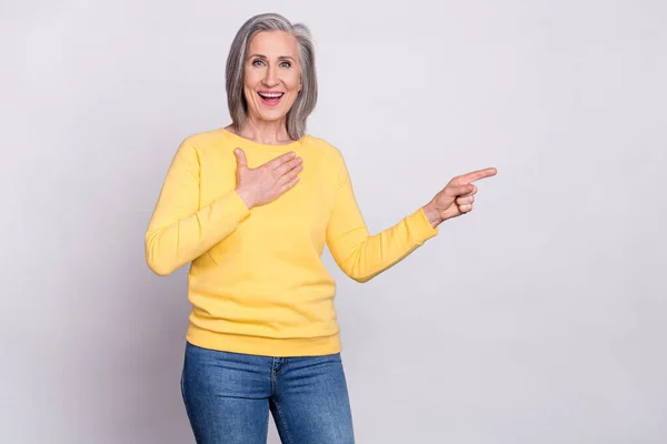 Photo of happy excited amazed surprised mature woman advertise product hold hand chest isolated on grey color background — Foto Stock