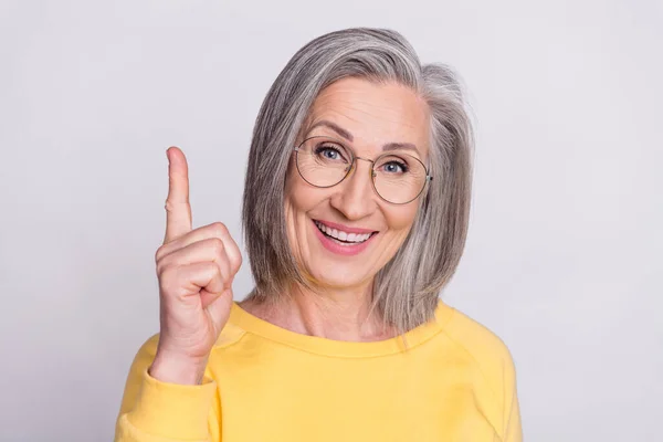 Photo of happy good mood charming grandmother in glasses point finger copyspace genius idea isolated on grey color background — Stockfoto