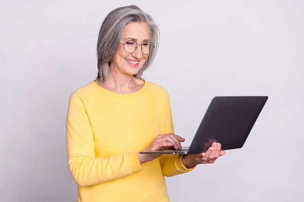 Photo of happy good mood businesswoman in glasses browsing in internet use laptop isolated on grey color background — Photo