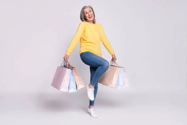 Full size photo of happy excited cheerful mature woman hold shopping bags isolated on grey color background —  Fotos de Stock