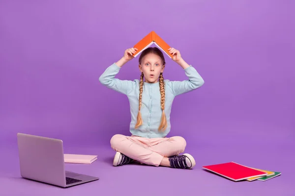 衝撃的な学習者の女の子の写真は、フロアブックの屋根のフォームは、青のシャツを着用孤立紫色の背景 — ストック写真