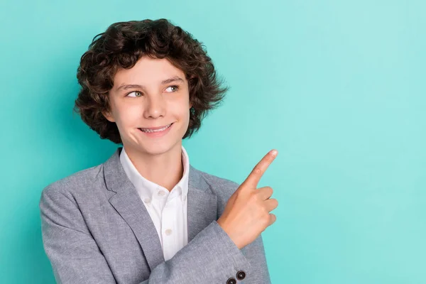 Photo of cute adorable schoolboy dressed grey suit smiling pointing finger empty space isolated teal color background — Fotografia de Stock