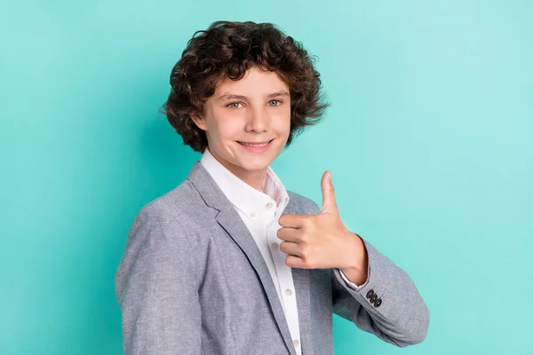 Foto van charmante mooie school jongen dragen grijze jas tonen duim omhoog glimlachen geïsoleerde turquoise kleur achtergrond — Stockfoto