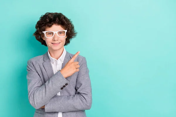 Photo of confident cute schoolboy dressed grey suit glasses smiling pointing finger empty space isolated teal color background — Fotografia de Stock