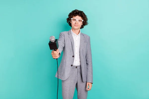 Photo of cute sweet schoolboy dressed grey suit glasses smiling holding microphone isolated teal color background — Foto Stock