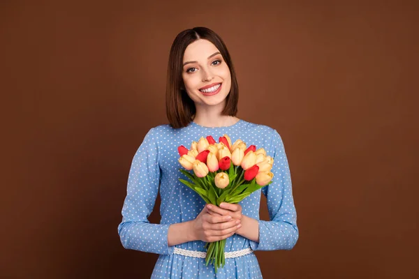 Foto van jong meisje blij positieve glimlach vieren verjaardag cadeau bloemen boeket geïsoleerd over bruine kleur achtergrond — Stockfoto
