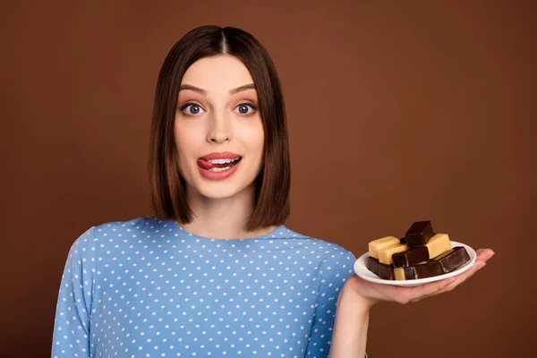 美しい短い髪型の写真若い女性のホールドお菓子は、茶色の色の背景に隔離された青のブラウスを着用 — ストック写真