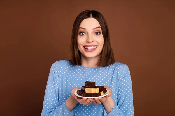 Foto de menina atraente jovem feliz sorriso positivo segurar doces dieta gostosa chocolate isolado sobre fundo de cor marrom — Fotografia de Stock