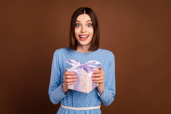 Foto de la joven chica emocionada feliz sonrisa positiva celebrar caja de regalo celebrar partido aislado sobre fondo de color marrón —  Fotos de Stock