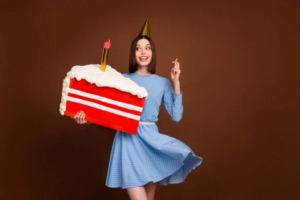 Foto von jungen Mädchen glücklich positives Lächeln machen Wunschkerze Geburtstagstorte isoliert über braunen Farbhintergrund — Stockfoto