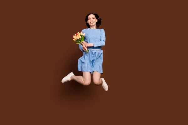 Full length photo of funny brunette lady jump with flowers wear blue dress isolated on brown background — Fotografia de Stock