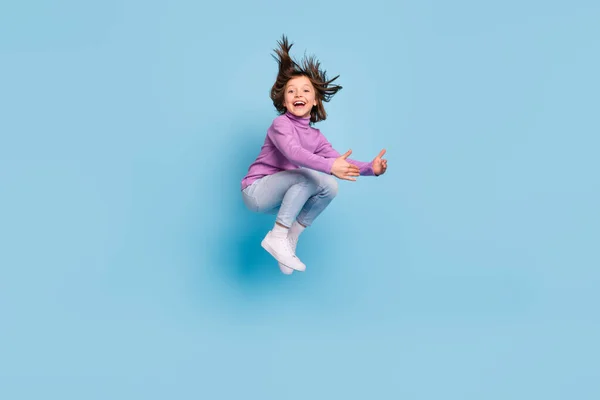 Longitud completa tamaño del cuerpo foto niña pequeña saltando abrazando aislado pastel color azul fondo —  Fotos de Stock