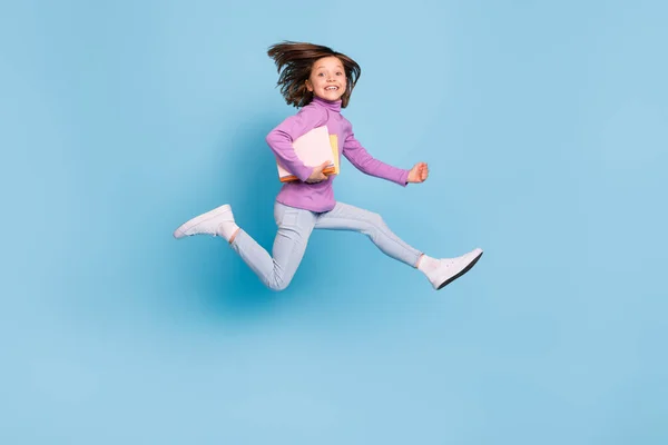 Full längd kropp storlek foto liten flicka hoppar upp hålla bok högen isolerad pastell blå färg bakgrund — Stockfoto