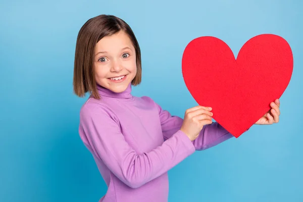 Портрет школьницы с изображением красной открытки в форме сердца изолированный пастельно-синий цвет фона — стоковое фото