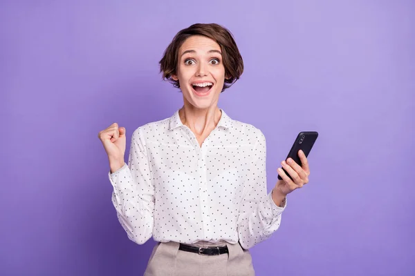 Portret van mooie brunette kort kapsel hoera dame houden telefoon dragen wit shirt geïsoleerd op lila kleur achtergrond — Stockfoto