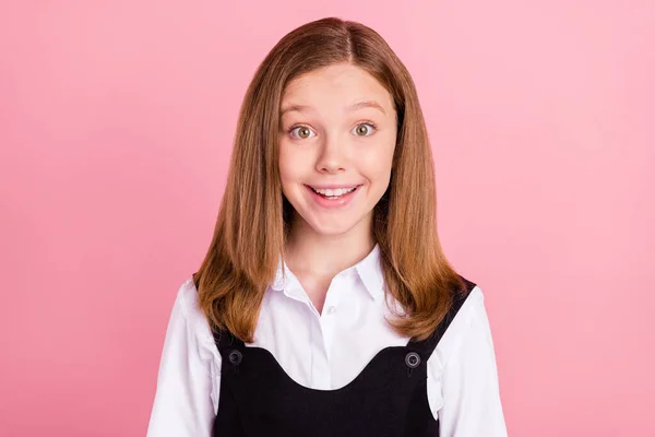 Foto de la divertida chica de la escuela emocionada usar negro blanco uniforme ojos grandes sonriendo aislado color rosa fondo — Foto de Stock