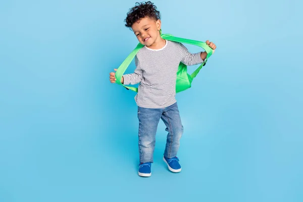 Plná délka tělo velikost pohled na pěkný veselý chlapec nosí tašku tanec izolované přes jasně modré barvy pozadí — Stock fotografie