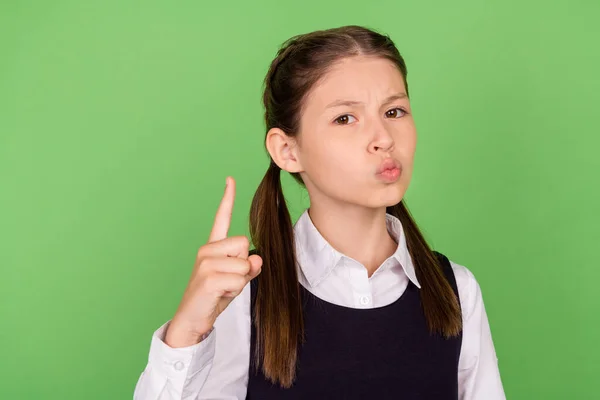 Foto de grave menina da escola rigorosa vestida roupas formais apontando dedo isolado cor verde fundo — Fotografia de Stock