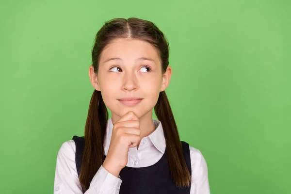 Foto de la encantadora chica de la escuela de ensueño vestida ropa formal brazo barbilla buscando espacio vacío aislado color verde fondo —  Fotos de Stock