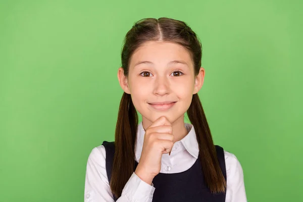 Foto retrato niña sonriendo pensativo tocar la barbilla con uniforme aislado pastel color verde fondo —  Fotos de Stock