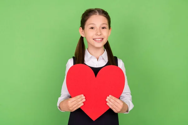 Foto retrato menina bonito alegre mantendo vermelho papel coração isolado pastel cor verde fundo — Fotografia de Stock