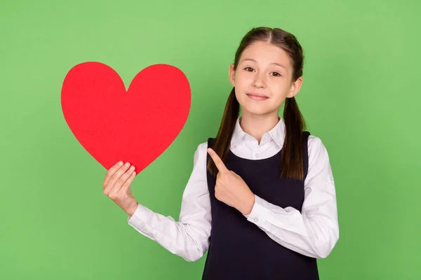 Foto retrato menina bonito alegre apontando vermelho papel coração namorados dia isolado pastel cor verde fundo — Fotografia de Stock