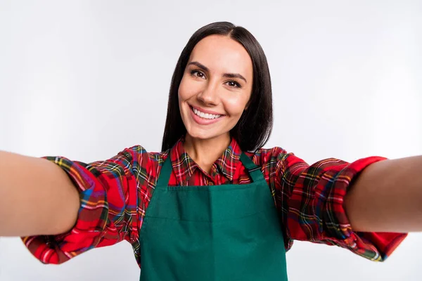 Foto di affascinante attraente giovane donna fare macchina fotografica selfie sorriso indossare grembiule camicia a quadri isolato su sfondo di colore grigio — Foto Stock