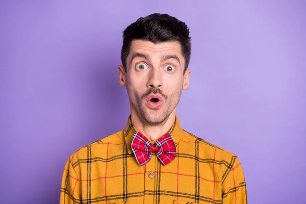 Foto de engraçado impressionado chocado jovem desgaste xadrez camisa arco gravata olhos grandes isolado cor violeta fundo — Fotografia de Stock