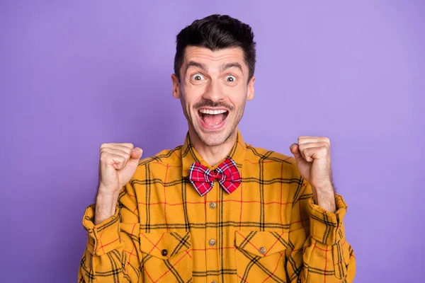 Foto de hombre joven emocionado feliz sonrisa positiva celebrar victoria victoria puños manos aisladas sobre fondo de color púrpura — Foto de Stock