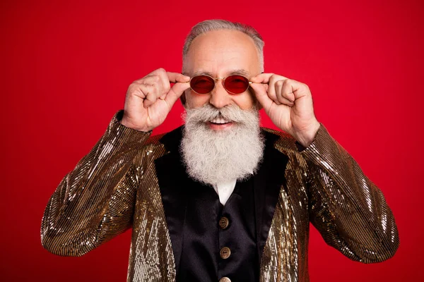 Komik beyaz sakallı, yaşlı illüzyonist adamın fotoğrafı kırmızı arka planda izole edilmiş gözlüklü altın takım elbise giyiyor. — Stok fotoğraf