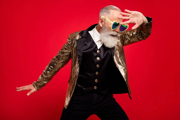 Yaşlanmış yakışıklı erkek performansının fotoğrafı kırmızı arkaplanda izole edilmiş gözlüklü sirk gösterisi takıyor. — Stok fotoğraf