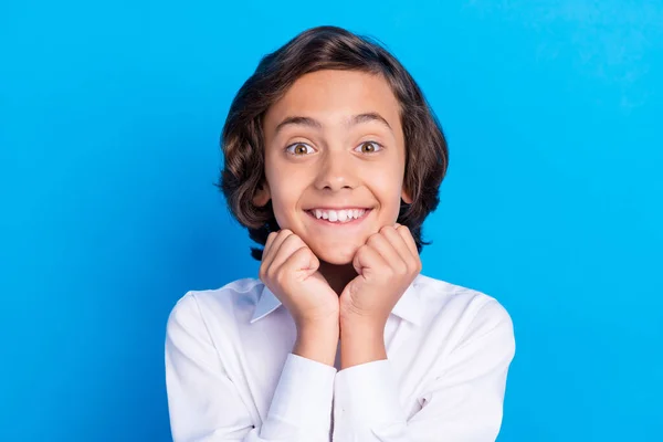 Foto de encantador colegial impresionado usar ropa formal brazos barbilla sonriente aislado color azul fondo —  Fotos de Stock