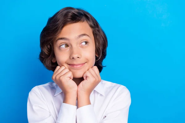 Foto de niño de la escuela bonita de ensueño usar traje formal brazos sonrientes barbilla buscando espacio vacío aislado color azul fondo —  Fotos de Stock