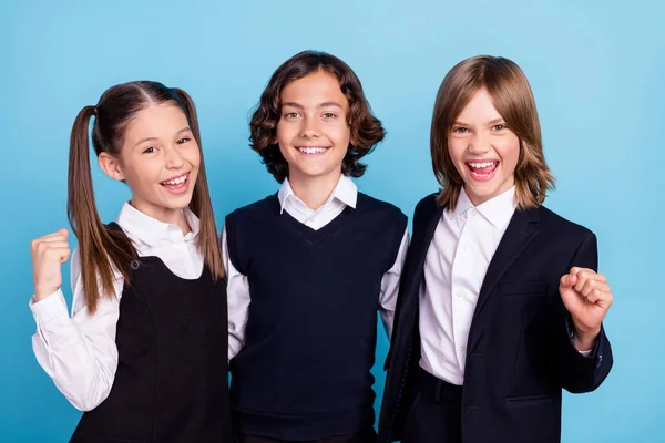 Photo of charming lucky schoolkids formalwear smiling embracing hugging rising fists isolated blue color background — Stock Photo, Image