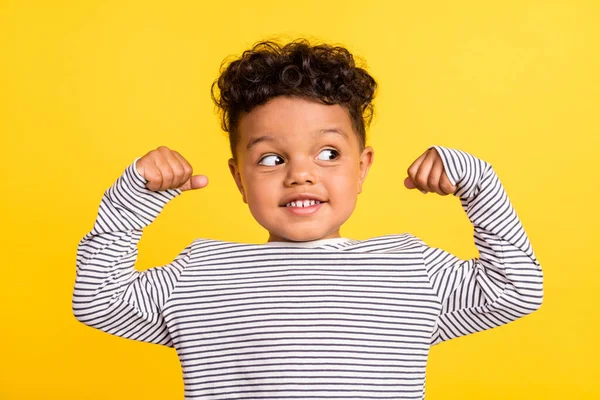 Foto retrato alegre niño pequeño buscando espacio en blanco que muestra manos fuertes aislado color amarillo brillante fondo —  Fotos de Stock