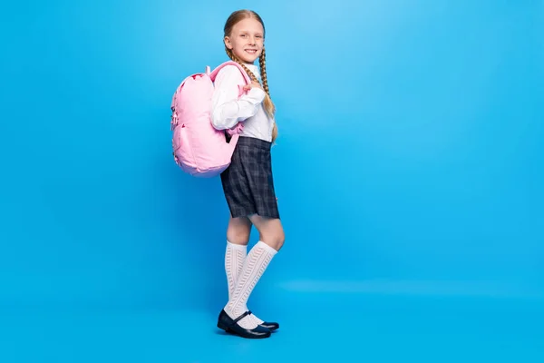 전체 몸길이의 사진, 배낭을 든 어린 소녀가 격리 된 파스텔푸른 배경을 가지고 학교에 가는 모습 — 스톡 사진
