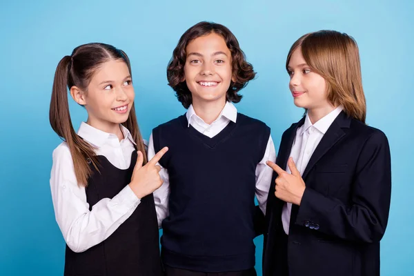 떼어 놓은 파스텔 푸른색 배경 위에 균일 한 손가락으로 미소를 짓고 있는 학교 친구 사진 촬영 — 스톡 사진